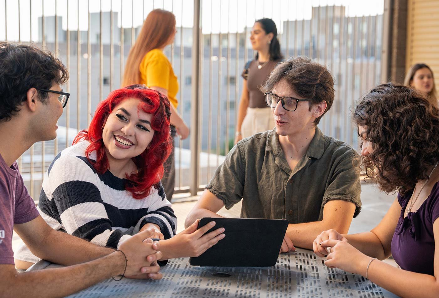 A lively table discussion unfolds as students work collaboratively with a tablet, highlighting the valuable connections made in ASU's Accountancy degree.
