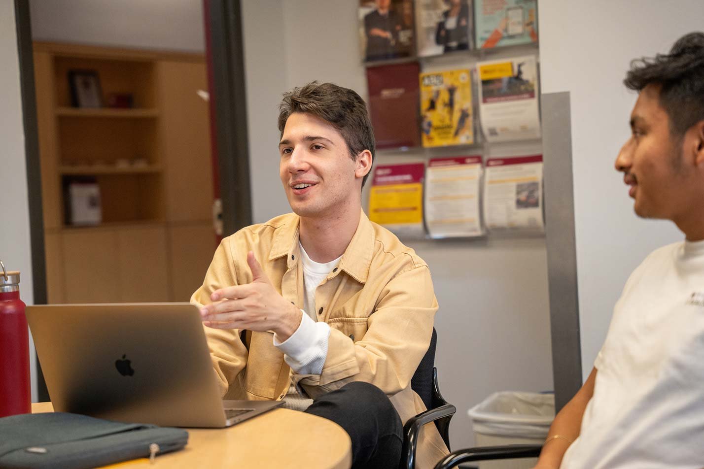 Gathered around a table, a students engage in discussion and illustrate communication skills vital for ASU's Business Data Analytics degree.