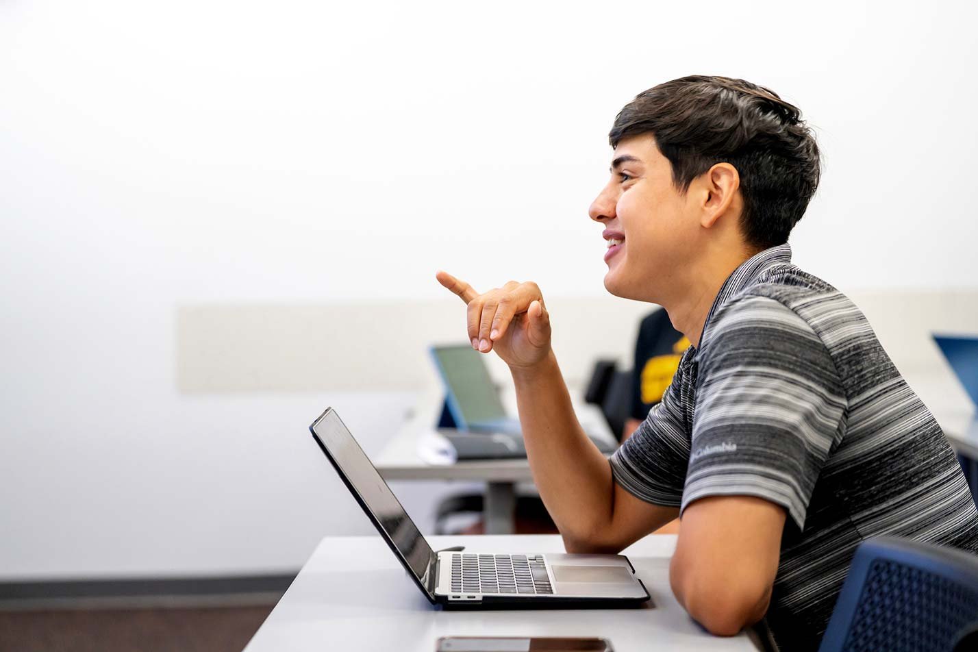 Laptops open, a classroom discussion draws active participation, illustrating engagement in ASU's Business degree.
