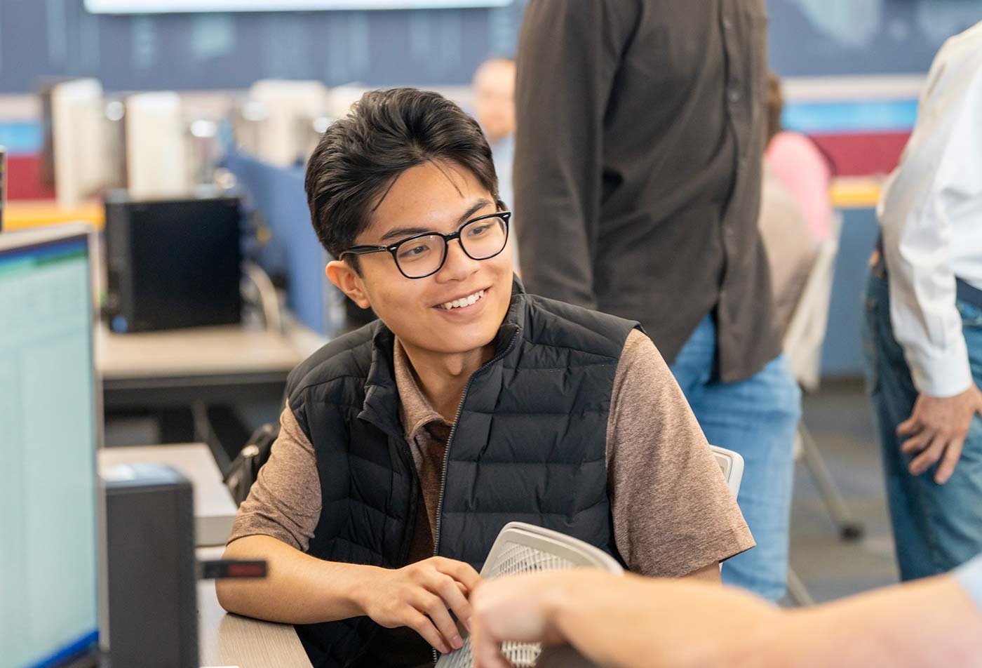 Students collaborate in a computer-filled classroom, highlighting teamwork in ASU's Business (Financial Planning) degree.