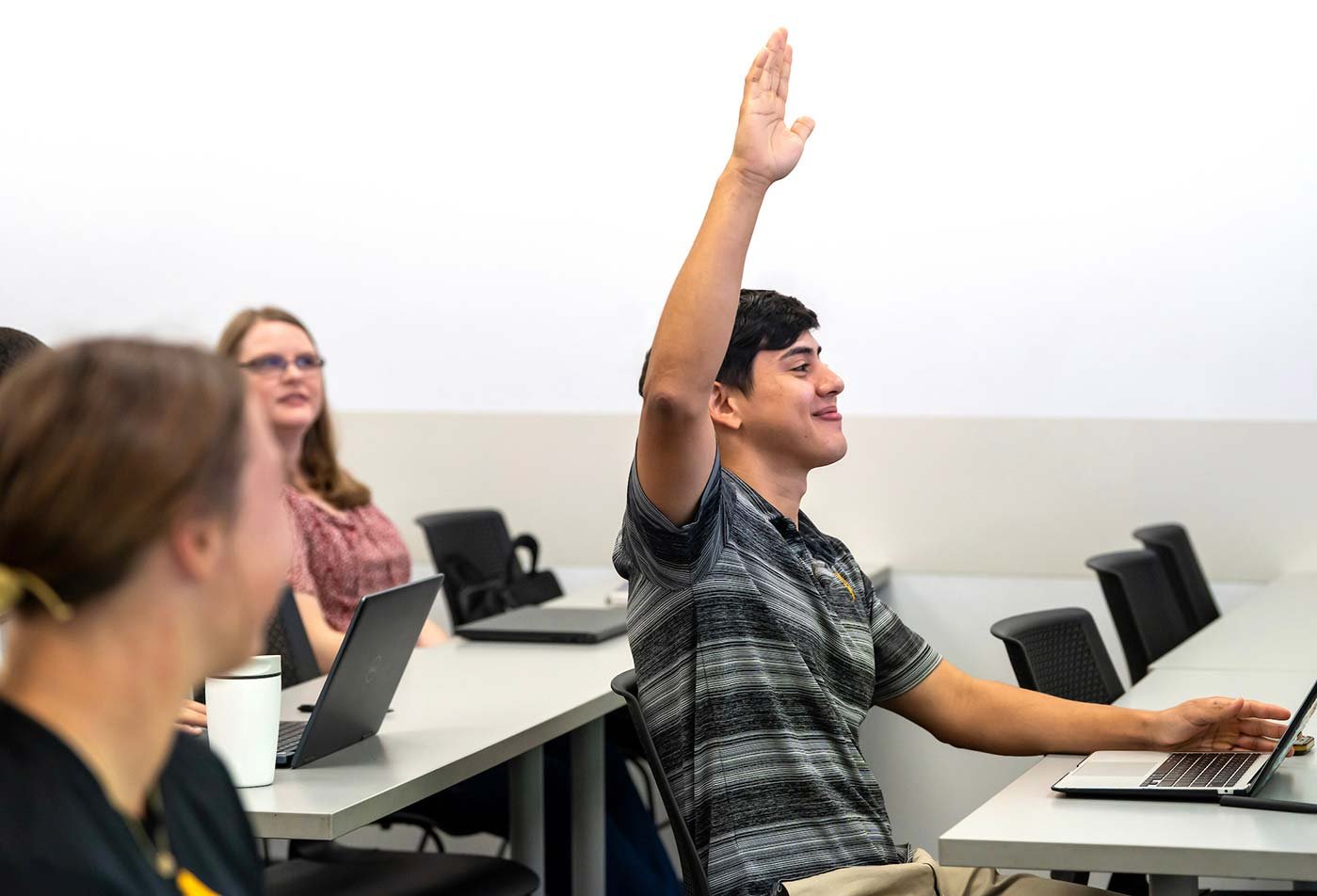 A student raises his hand in a classroom discussion, highlighting interactive learning in ASU's Agribusiness Innovation and Technology concentration.