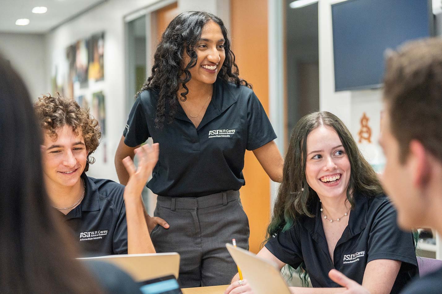 W.P. Carey students engage in discussion around a table, highlighting teamwork in ASU's Business (Law) degree.