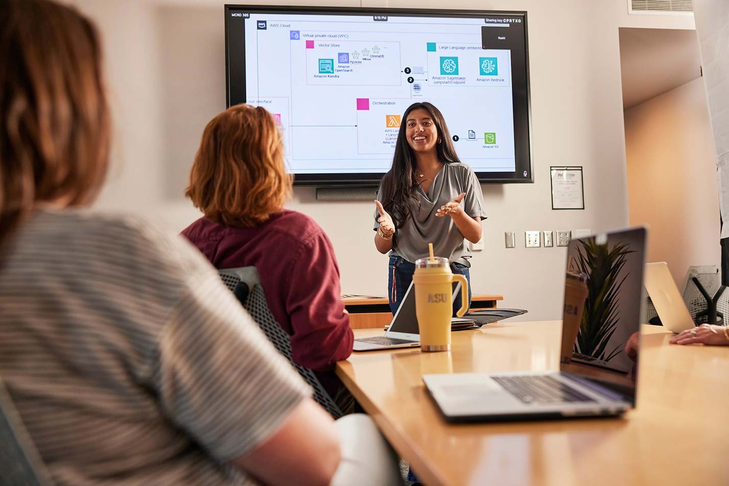 A student presents project details to using a flowchart on a tv screen, reflecting real-world learning in ASU's Computer Information Systems degree.