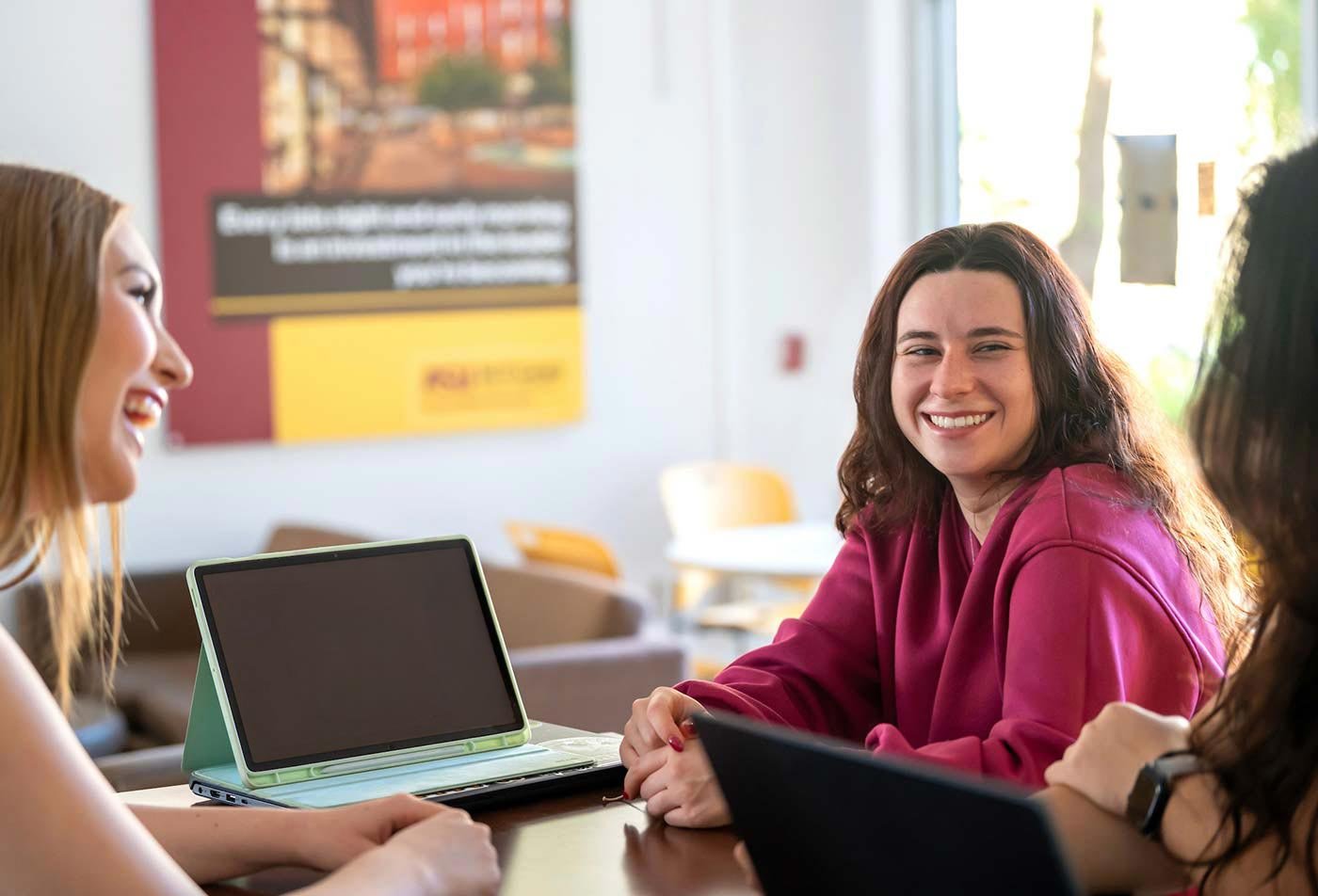 Around a table, students collaborate on a project, showcasing teamwork essential to ASU's Digital Business Innovation certificate program.