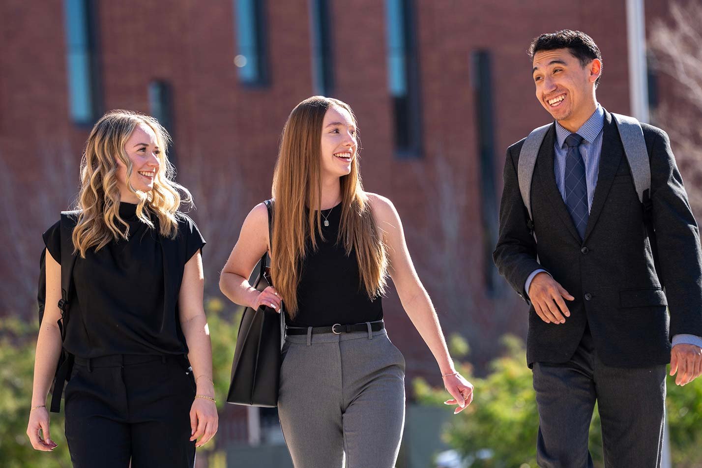 Students in professional attire walk together on campus, showcasing the valuable connections made through ASU's Essentials of Credit and Leasing program.