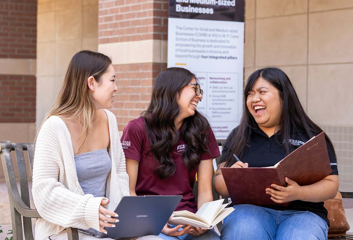 Students laugh together as they discuss a project, highlighting the valuable connections made through ASU's BA in Entrepreneurial Leadership program.