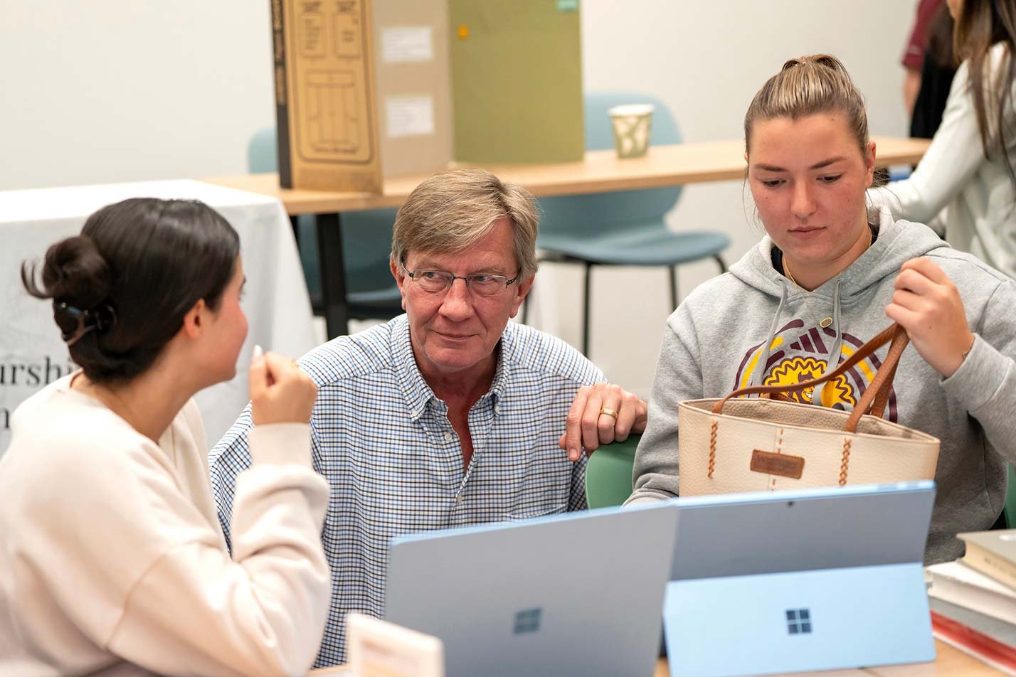 Students discuss their project in a classroom with an instructor, demonstrating hands-on learning in ASU's Food Industry Management and Marketing certificate program.