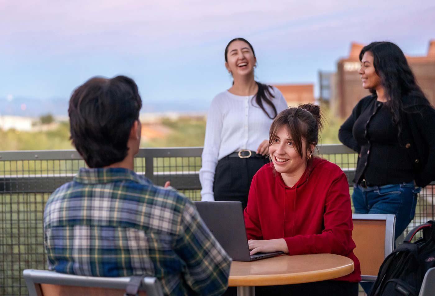 At an outdoor table with a scenic view, students engage in a discussion, highlighting the valuable connections made in ASU's Financial Technology degree.