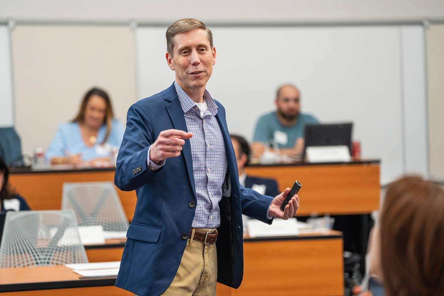 An instructor presents to a discussion-focused classroom, highlighting interactive learning in ASU's PhD in Management program.