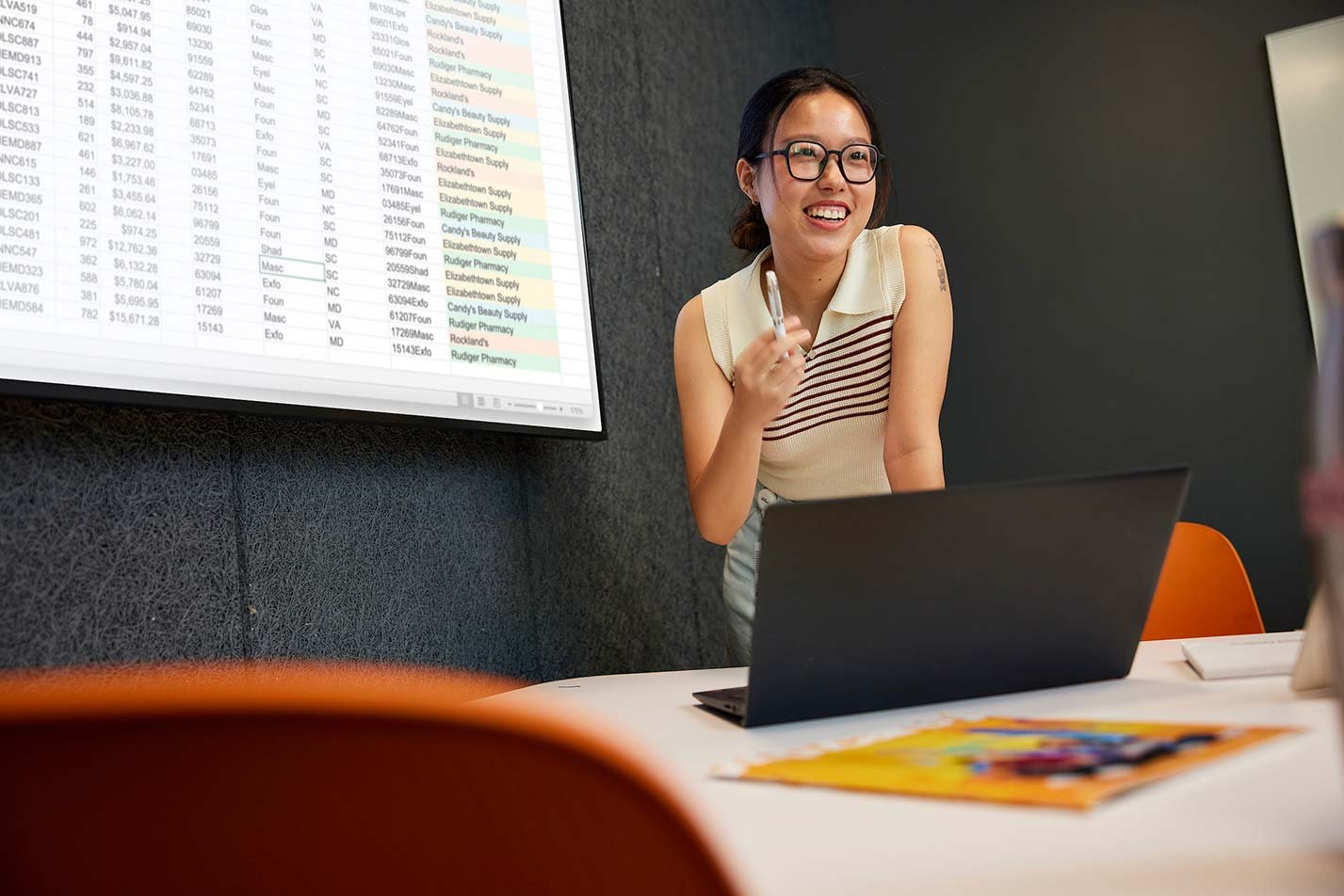 A presentation in front of data-filled screens showcases practical skills learned in ASU's Marketing (Digital) degree.