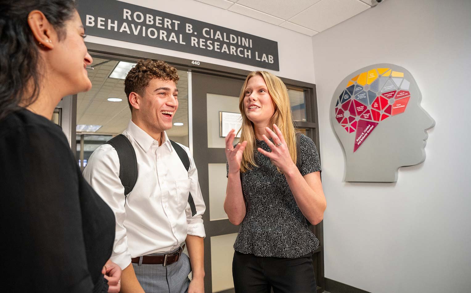 Outside the Robert B. Cialdini Behavioral Research Lab, a lively conversation showcases collaborative learning in ASU's Marketing degree.