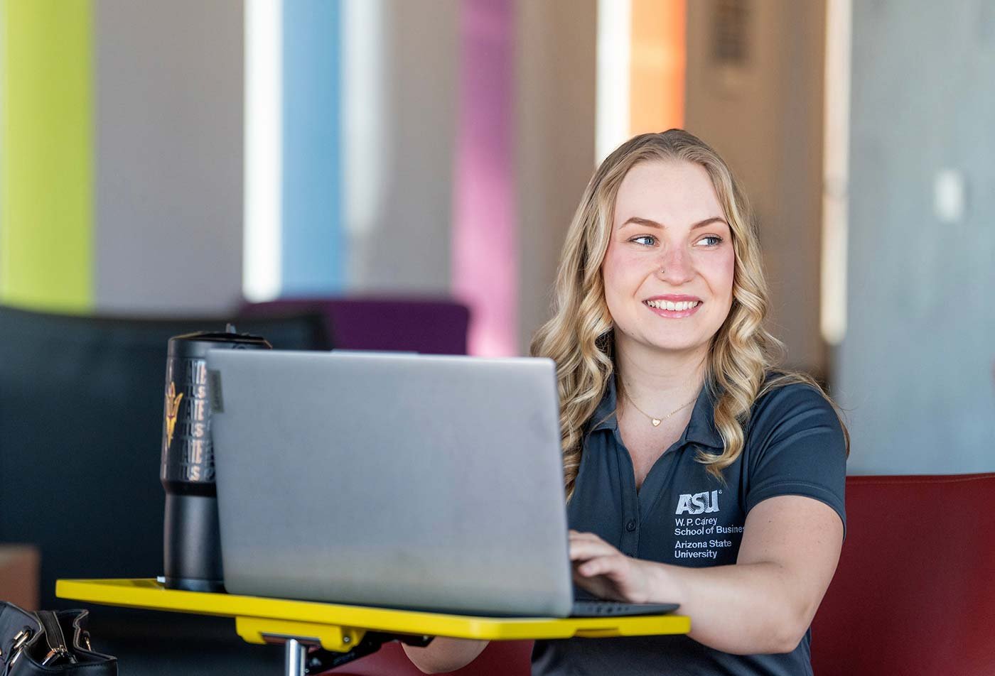 A student works on her laptop, highlighting flexibilty in ASU's W. P. Carey MBA - Online Program.