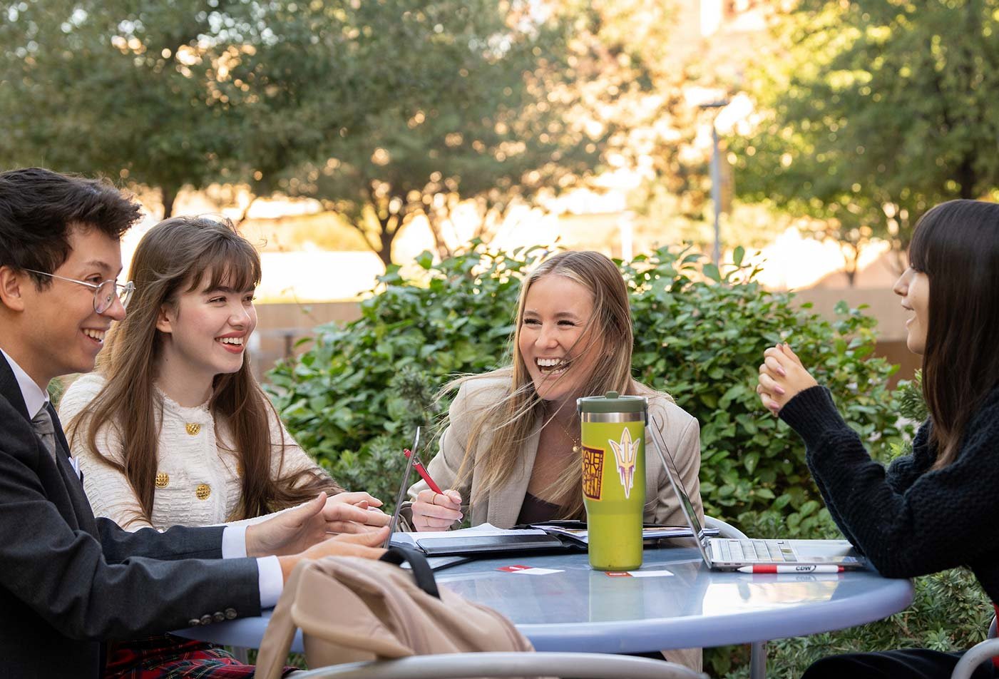 Around an outdoor table, a lively discussion showcases collaboration and teamwork in ASU's Professional Sales certificate program.