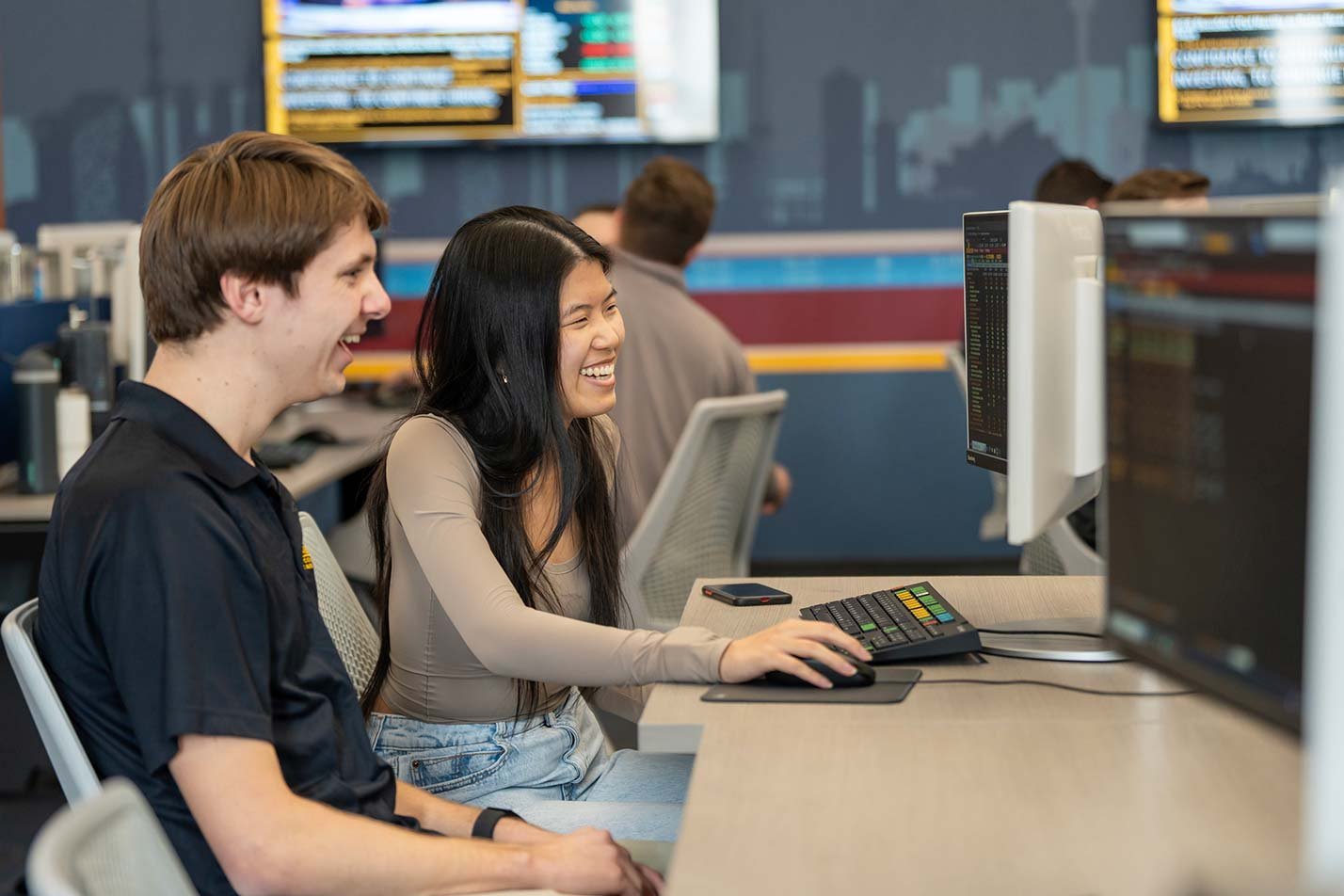 Studenets engage with computer screens in a collaborative workspace, illustrating active learning in ASU's Real Estate and Applied Finance degree.