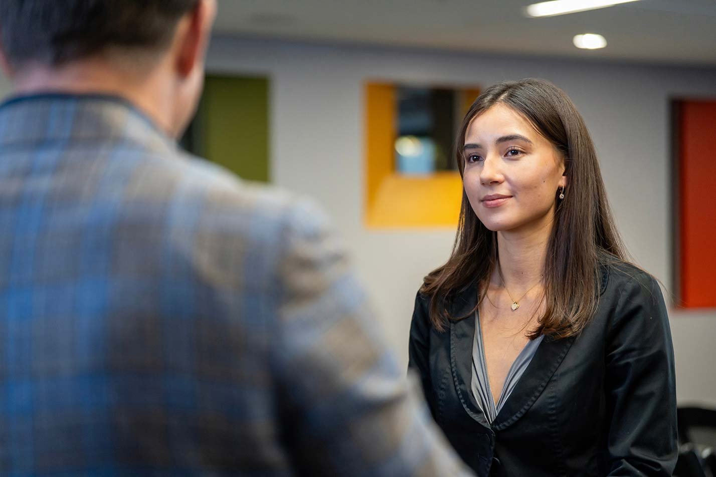 A woman attentively engages in conversation, highlighting interpersonal skills in ASU's Risk Management certificate program.