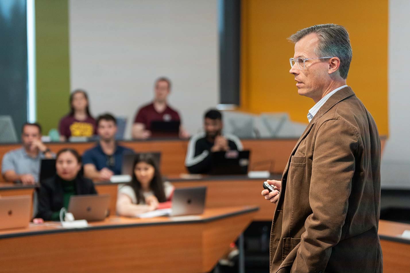 A lecture in a modern classroom draws attentive listeners, emphasizing engagement in ASU's Business Administration, DBA degree.