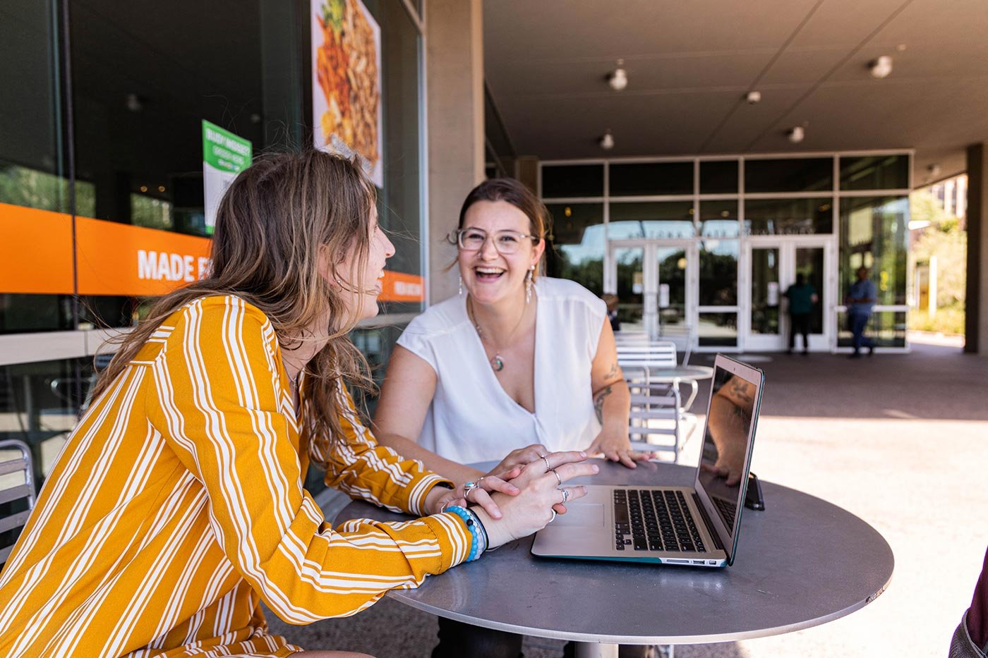 Students sit outside, collaborating on a laptop, embodying the collaborative spirit of ASU's certificate program in Digital Audiences.