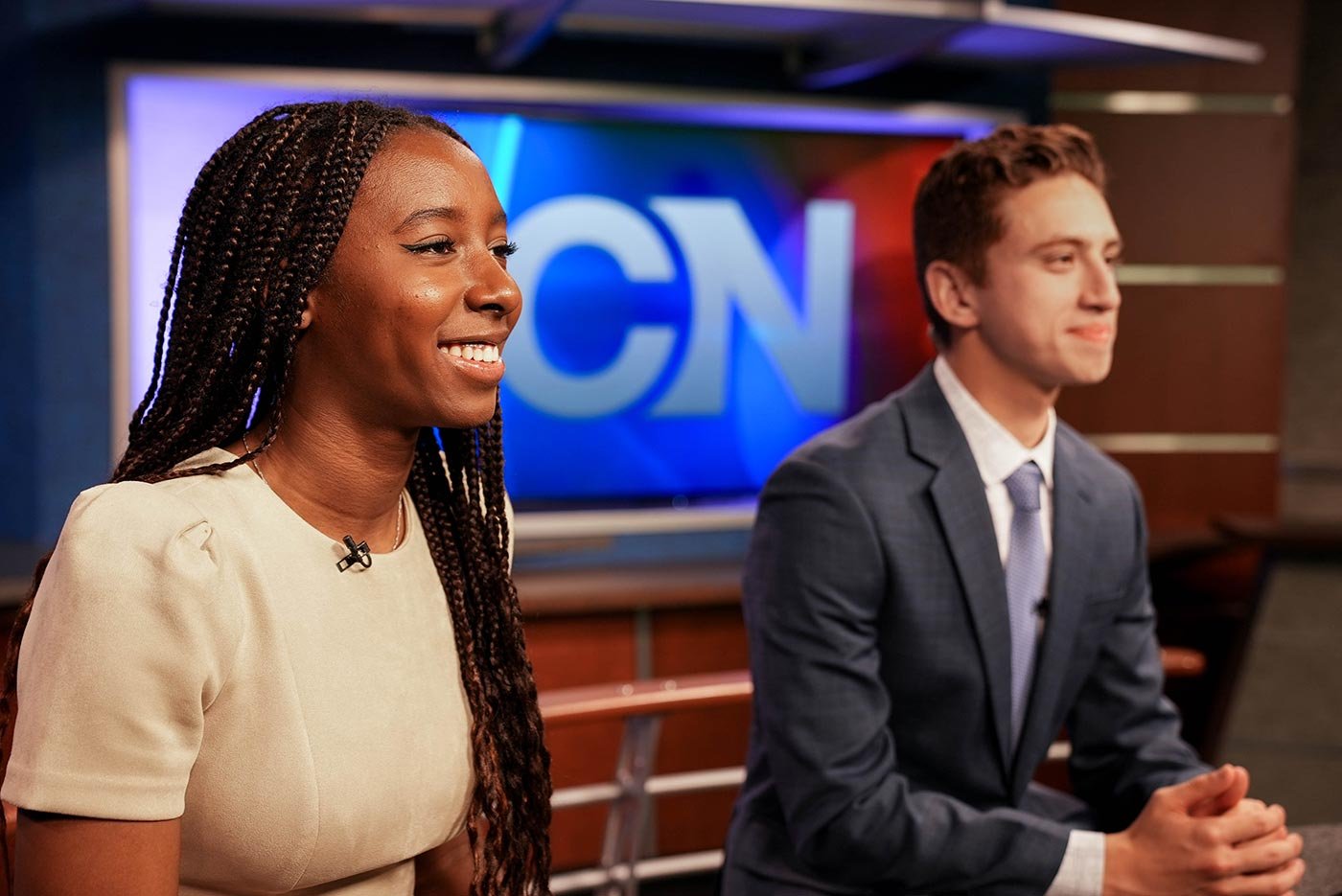 Two students engage in an on-air news presentation, showcasing practical skills in ASU's BA in Journalism program.