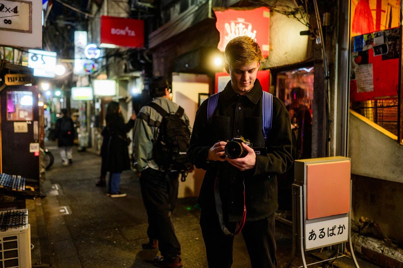 Student holds a camera, preparing to capture the lively street scene around him, the immersive experiences offered in ASU's MA Journalism program.