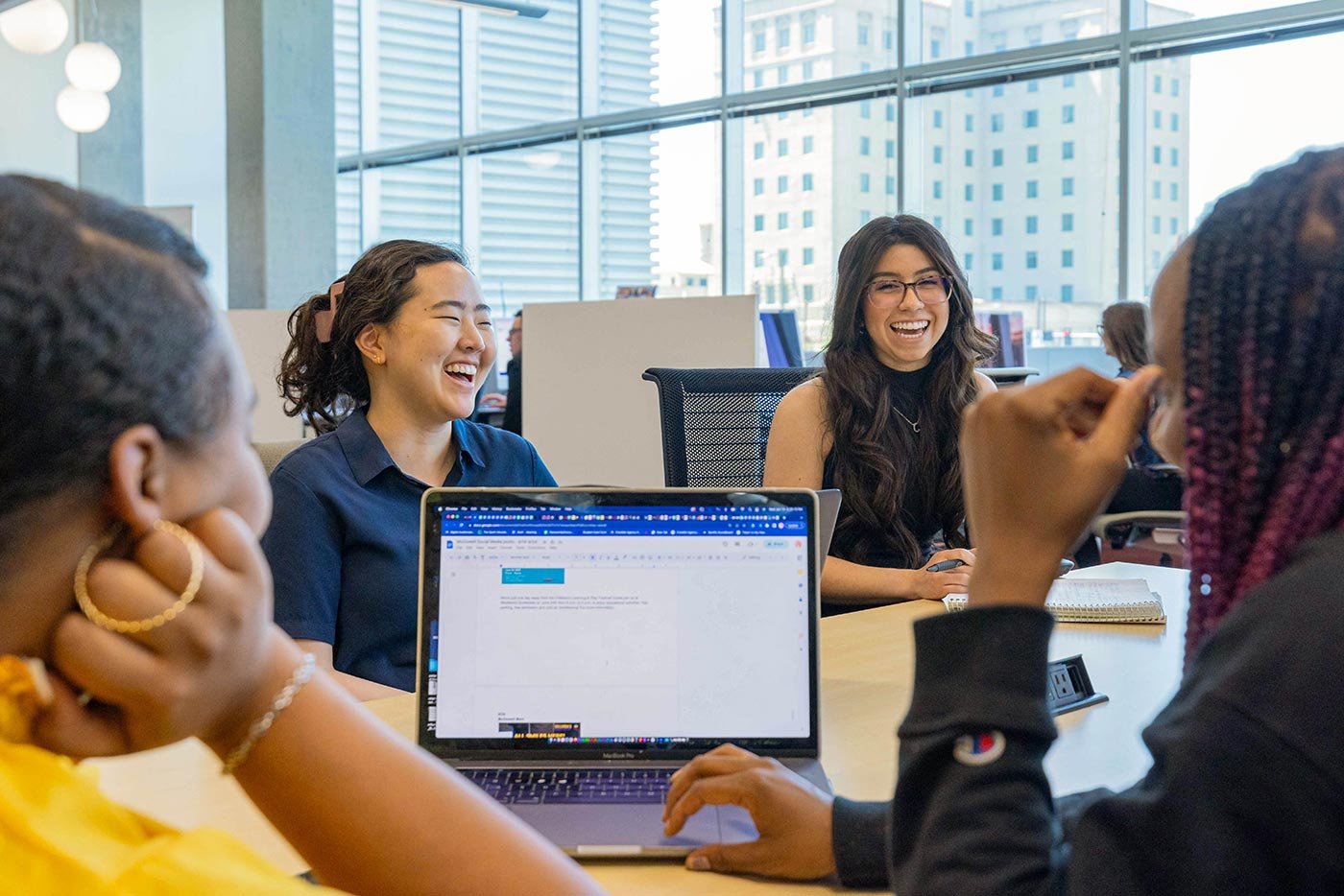 Students collaborate on a project around a table, showing the teamwork essential in ASU's Mass Communication and Media Studies program.