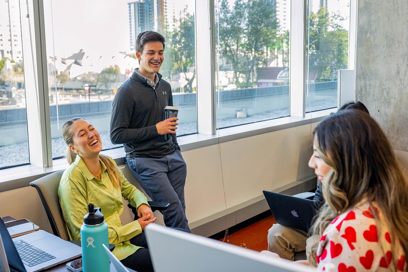 Students collaborate in a bright classroom, exemplifying teamwork in ASU's MS in Media Research and Technology degree.