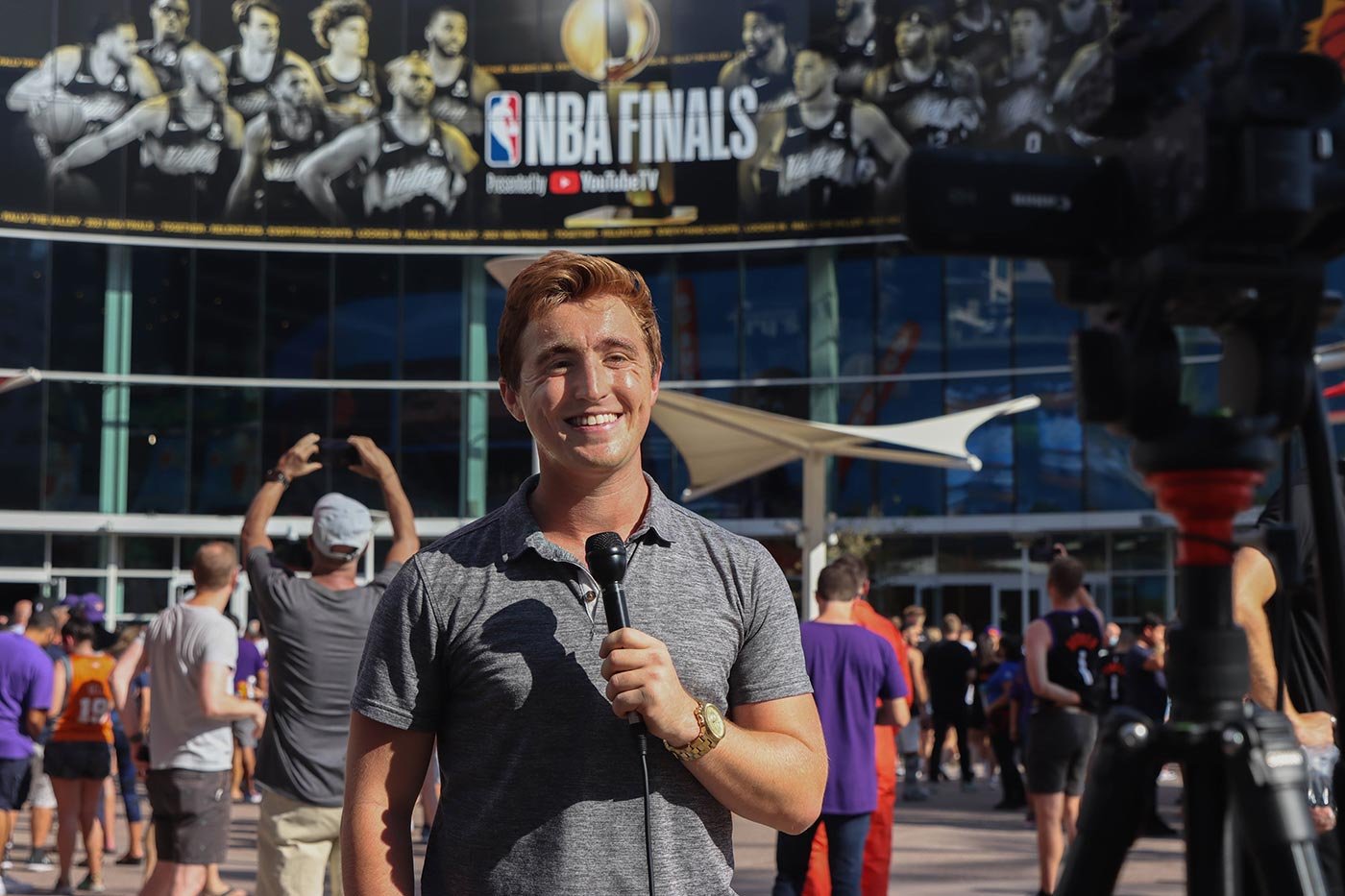 A student reporter enthusiastically conducts interviews outside a bustling event, showcasing skills essential for ASU's BA in Sports Journalism degree.