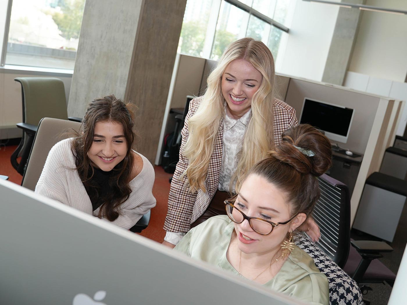 Students collaborate and engage with each other while working on a project in a brightly lit classroom, showcasing teamwork in ASU's MA in Strategic Communication degree.