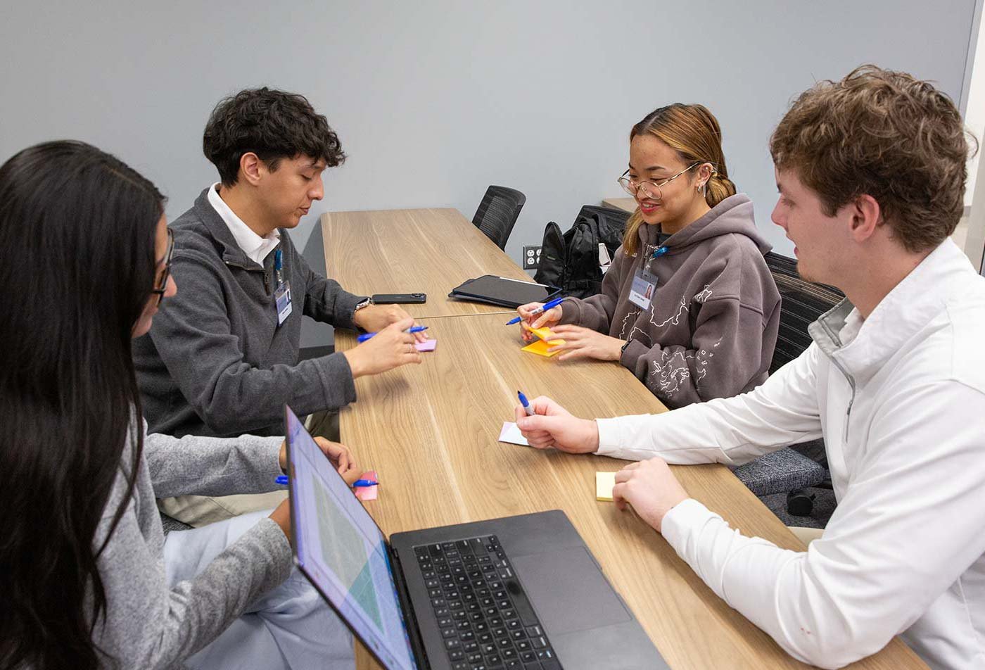 Students brainstorm with sticky notes and a laptop, highlighting the collaboration in ASU's Artificial Intelligence Engineering (Intelligent Biomedical Systems Engineering) degree.