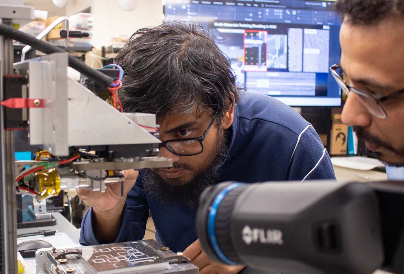 Students focus on a 3D printer in a manufacturing lab, highlighting skills in ASU's MS in Artificial Intelligence Engineering (Manufacturing) degree.