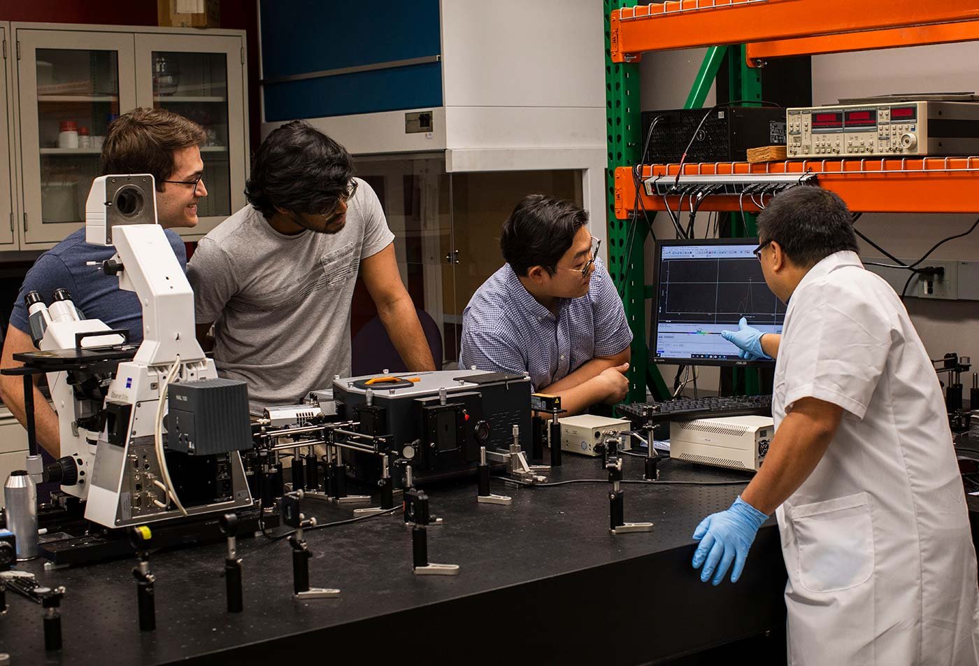Graduate students analyze data around a lab counter, illustrating hands-on learning in ASU's MS in Artificial Intelligence Engineering (Materials Science and Engineering) program.