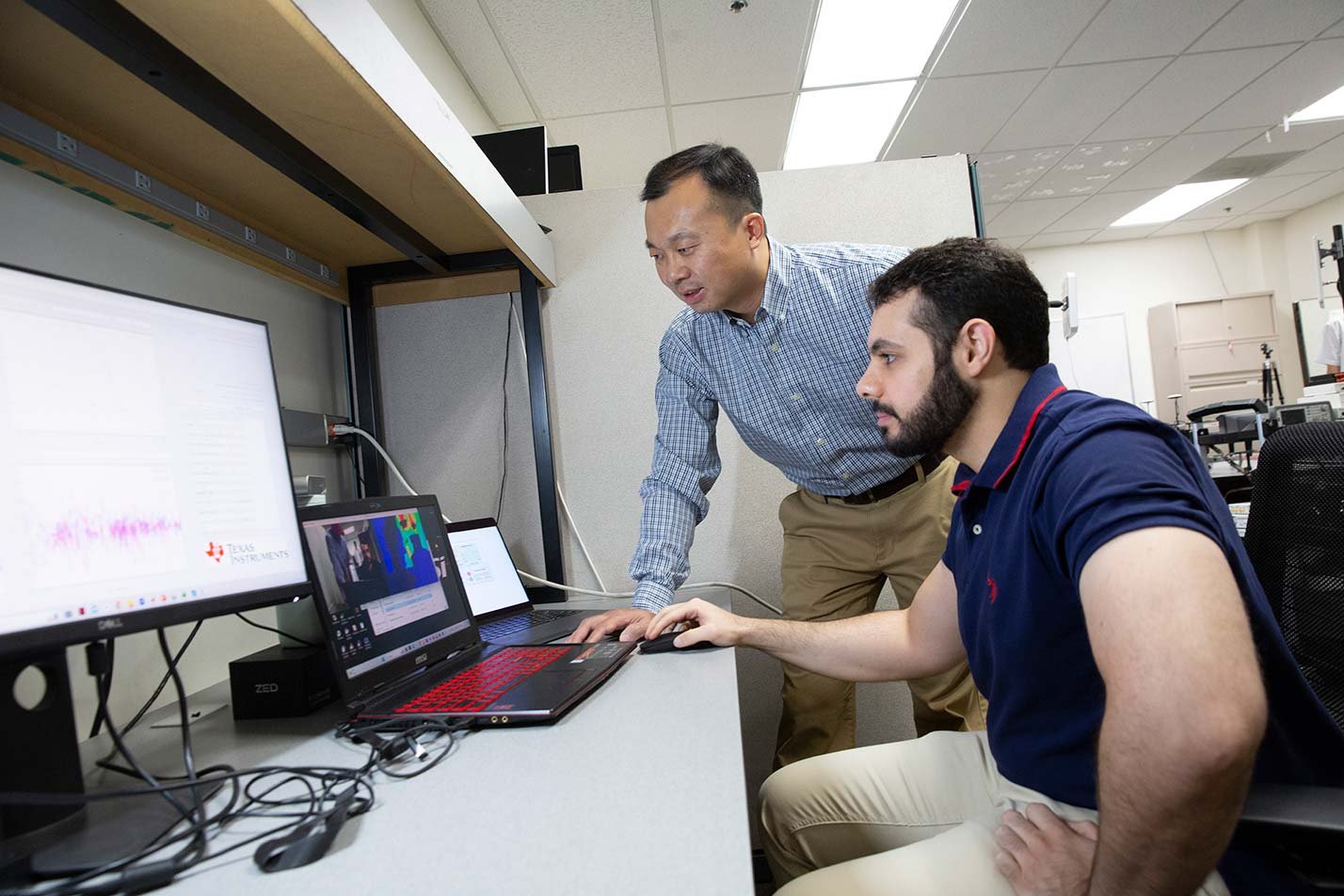 A professor and researcher analyze technical data, reflecting innovation in ASU's Electrical Engineering (Media Arts and Sciences), PhD program.