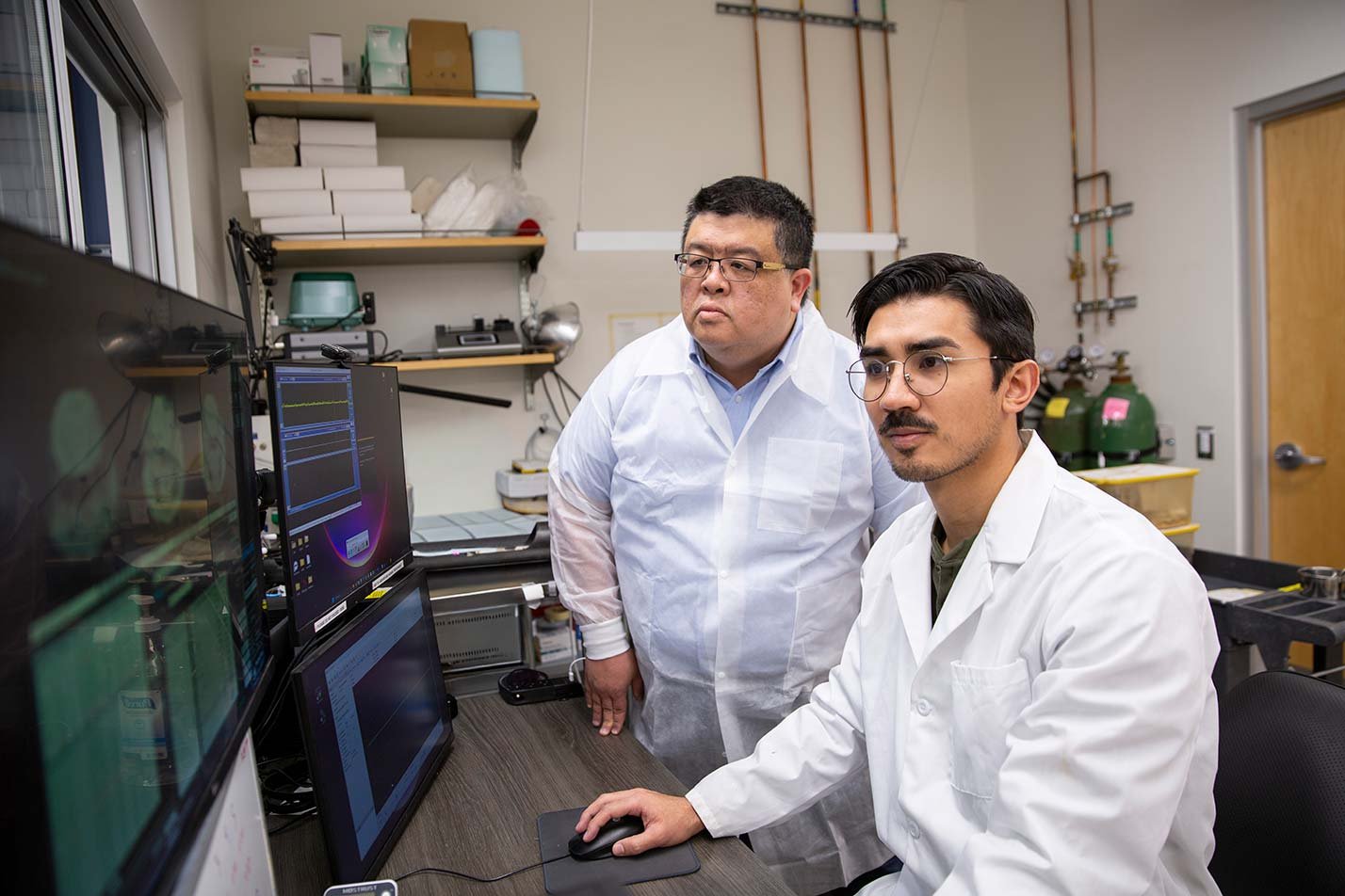 A professor and a student analyze data together in a lab, reflecting collaborative research experiences in ASU's Biological Design, MS program.