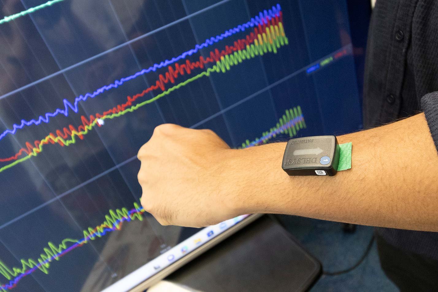 A heart monitor on a student's wrist displays fluctuating health data, showcasing practical learning in ASU's Biomedical Engineering degree.