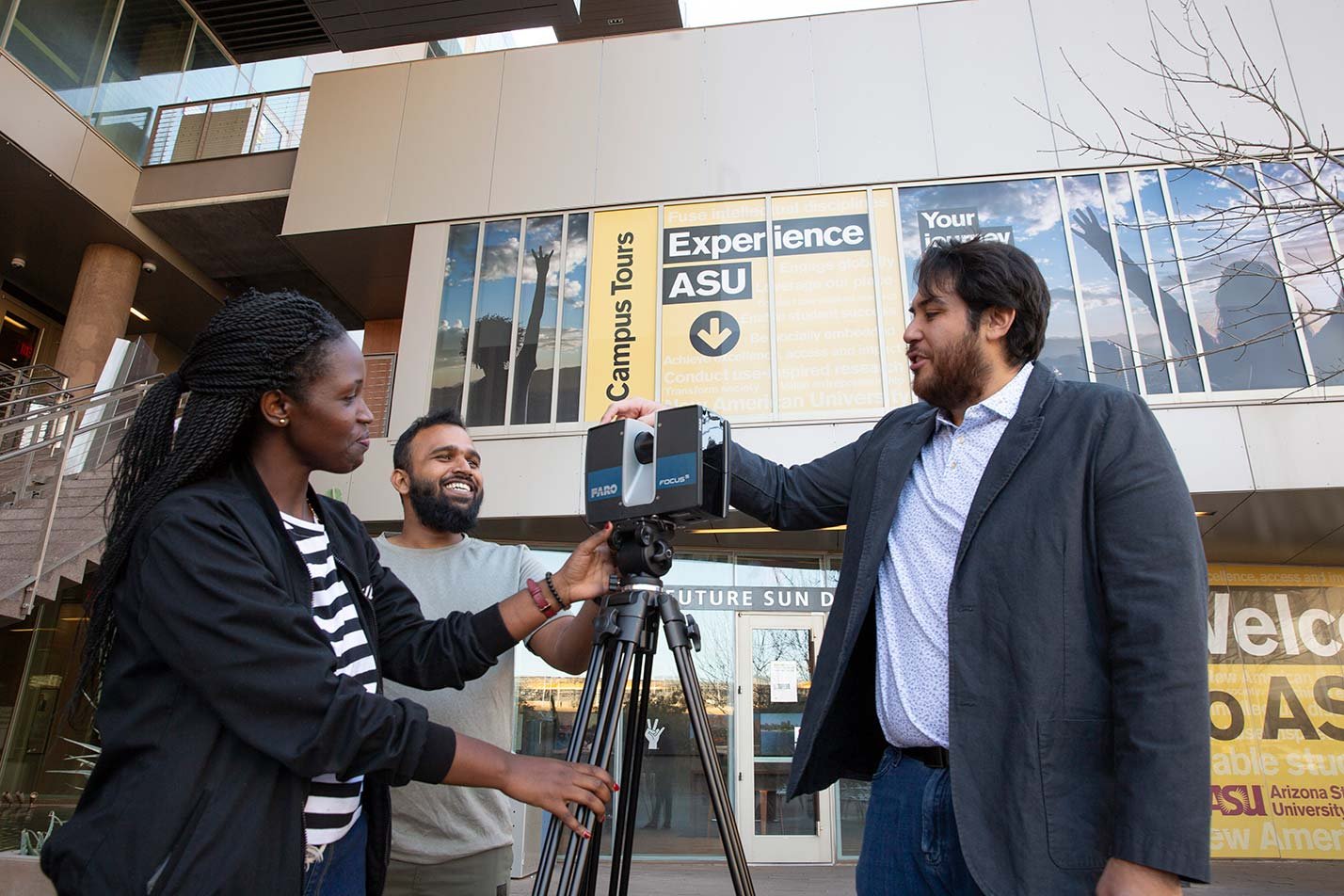 Students handle a LIDAR scanner outdoors, showcasing practical skills in ASU's Civil, Environmental and Sustainable Engineering PhD program.