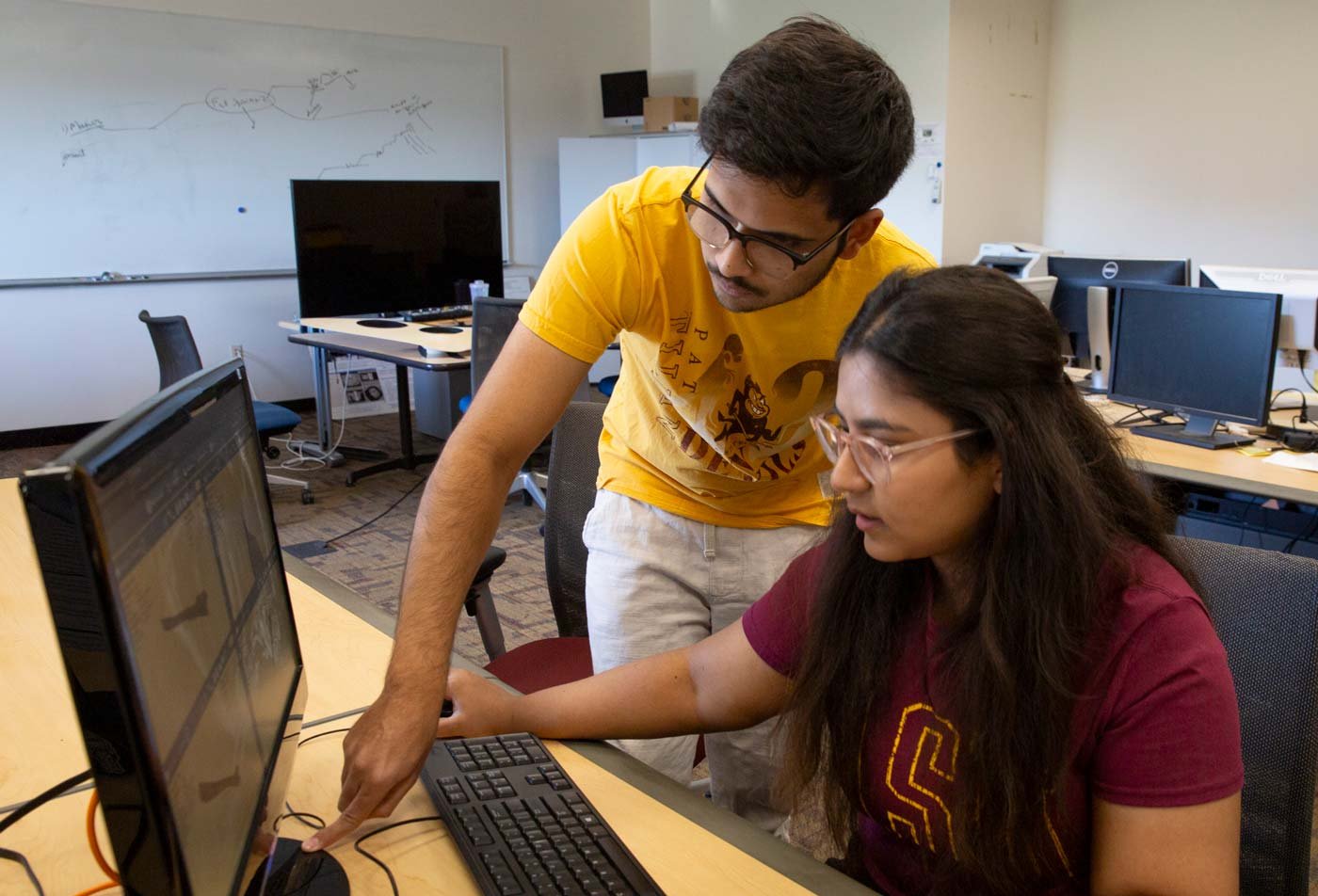 Two students collaborate at a computer in a lab, building hands-on skills in ASU's Computer Science, MCS degree.