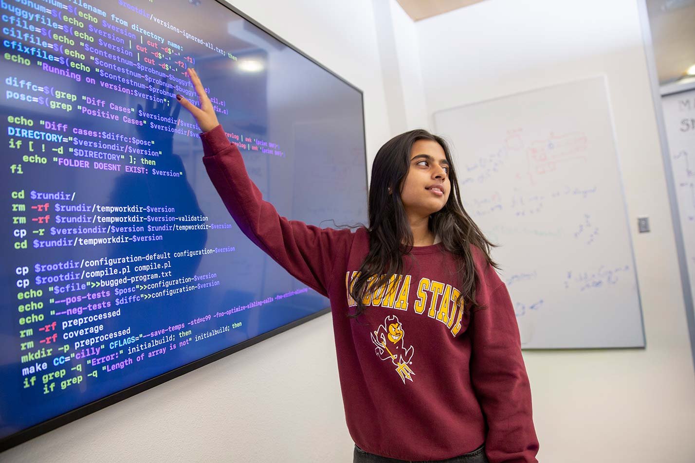 A student presents code on a digital display, showcasing advanced computing concepts in ASU's Computer Science, MS degree.
