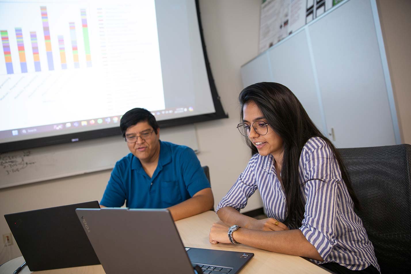 Researchers collaborate over laptops during a project meeting, reflecting doctoral research in ASU's Computer Science, PhD degree.