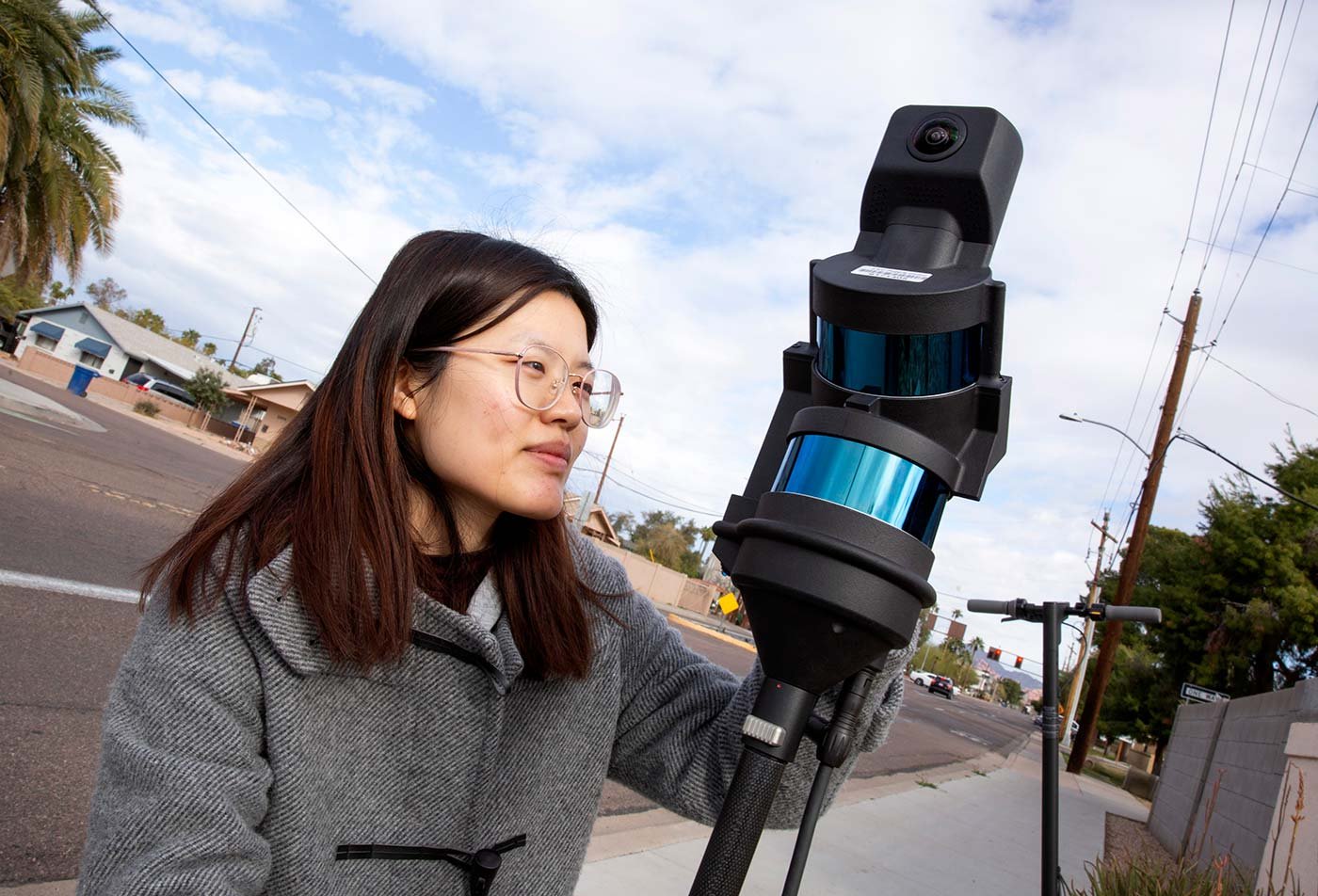 A researcher operates field-scanning equipment outdoors, applying practical analysis in ASU's Construction Management and Technology, MS degree.