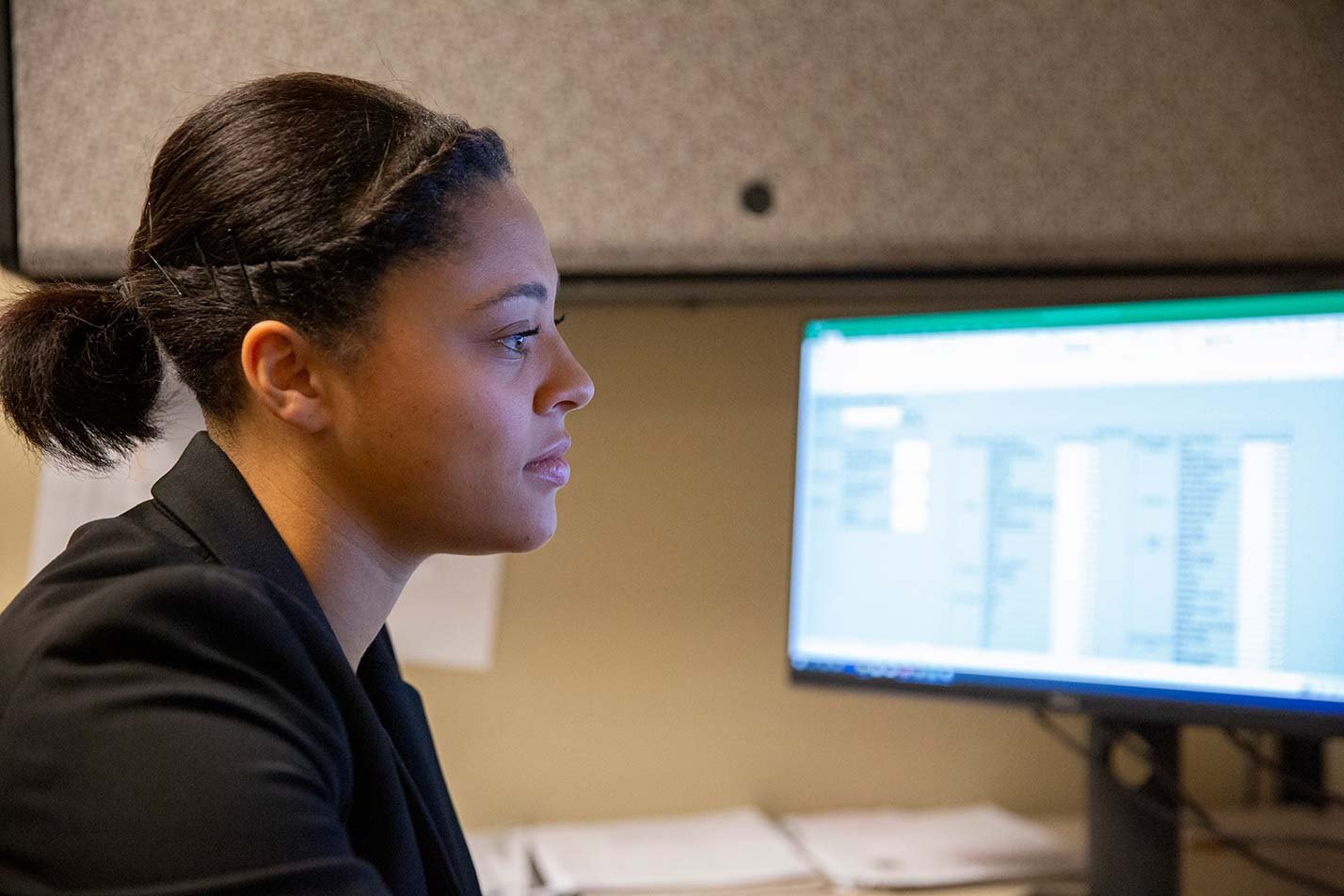 A student analyzes data on a computer with a spreadsheet on screen, showcasing practical skills for ASU's BS in Informatics degree.