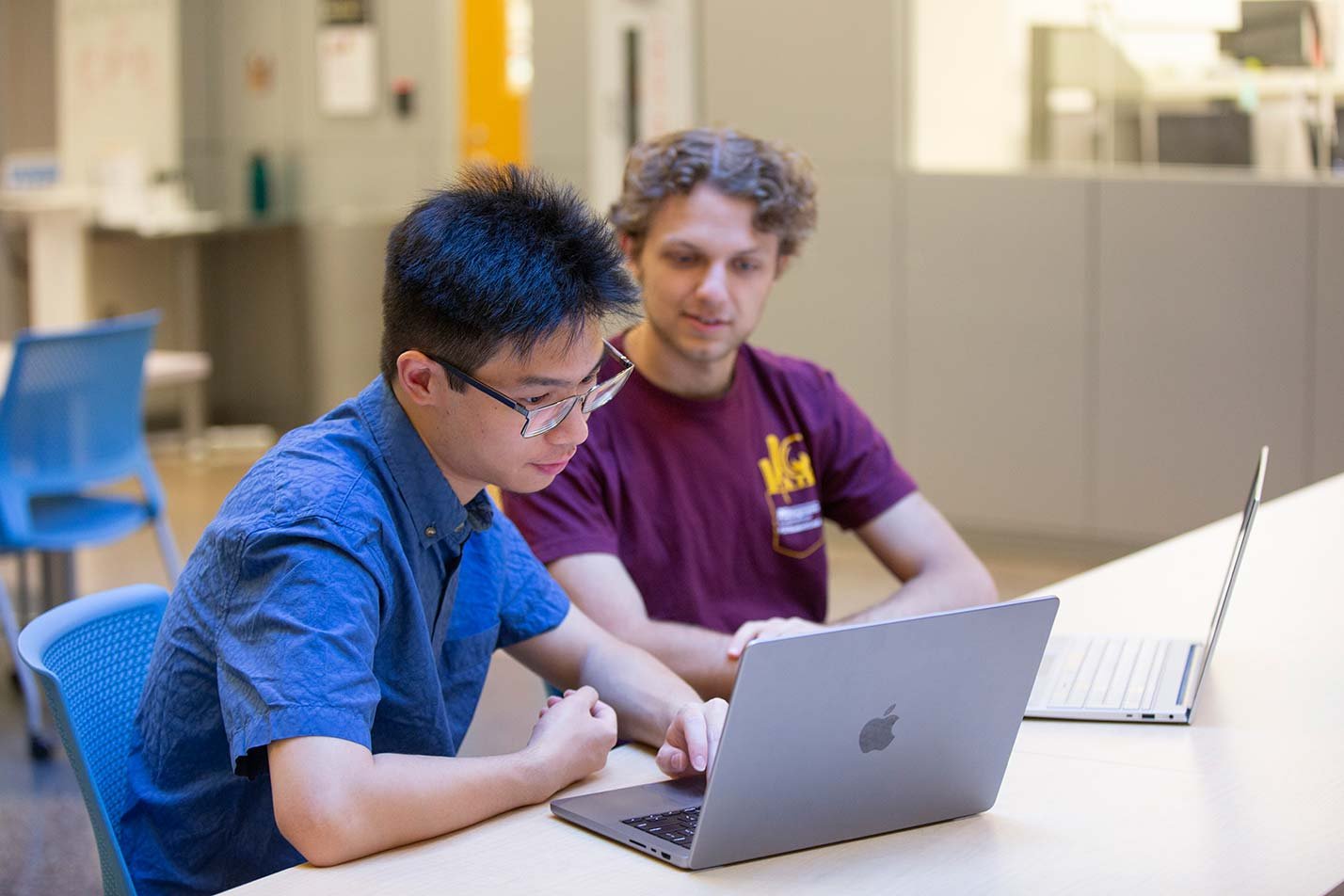 Students collaborate on a laptop, highlighting problem-solving in ASU's MS in Computer Science (Artificial Intelligence) program.