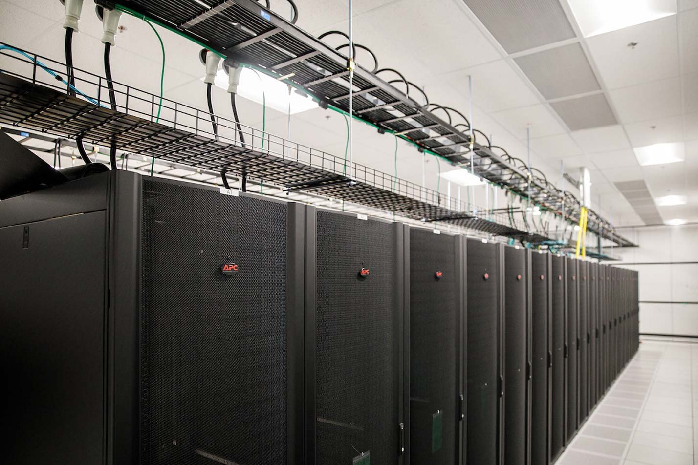 Server racks and organized cabling fill a data center, representing infrastructure for ASU's Computer Science (Big Data Systems), MCS degree.