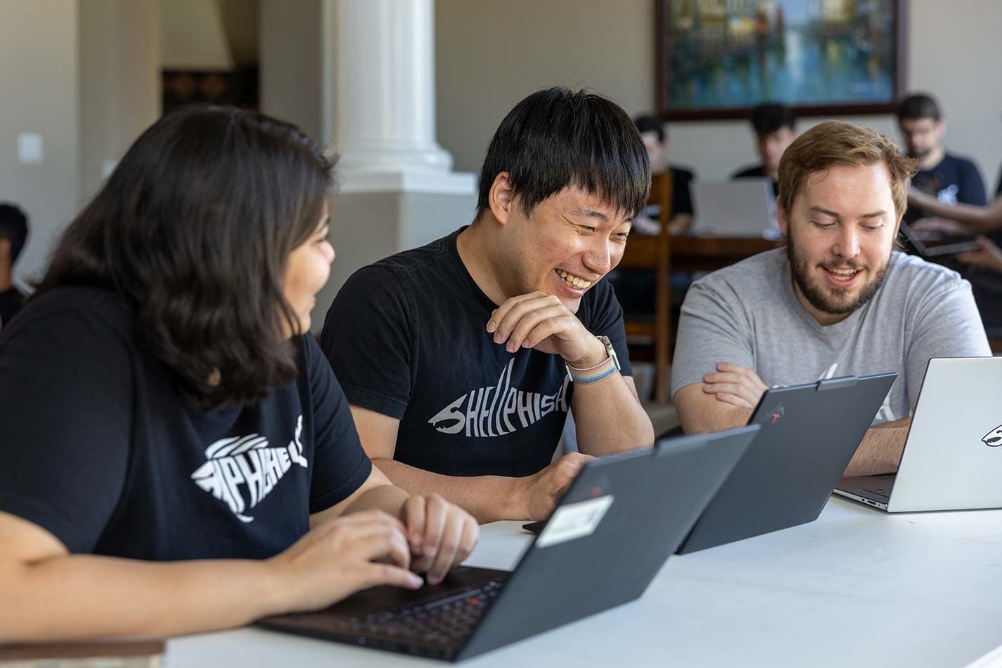 Students collaborate while coding on laptops, illustrating the collaborative spirit found in ASU's Computer Science (Cybersecurity) degree.