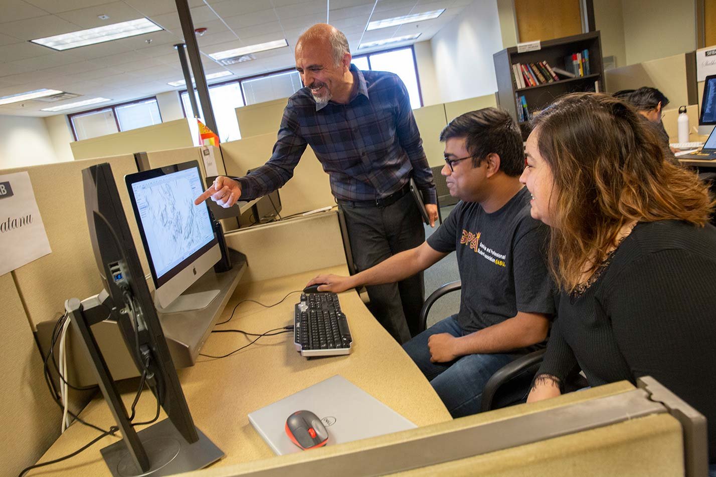 A professor points at a screen as students observe, highlighting collaborative learning in ASU's Computer Systems Engineering (Cybersecurity) program.