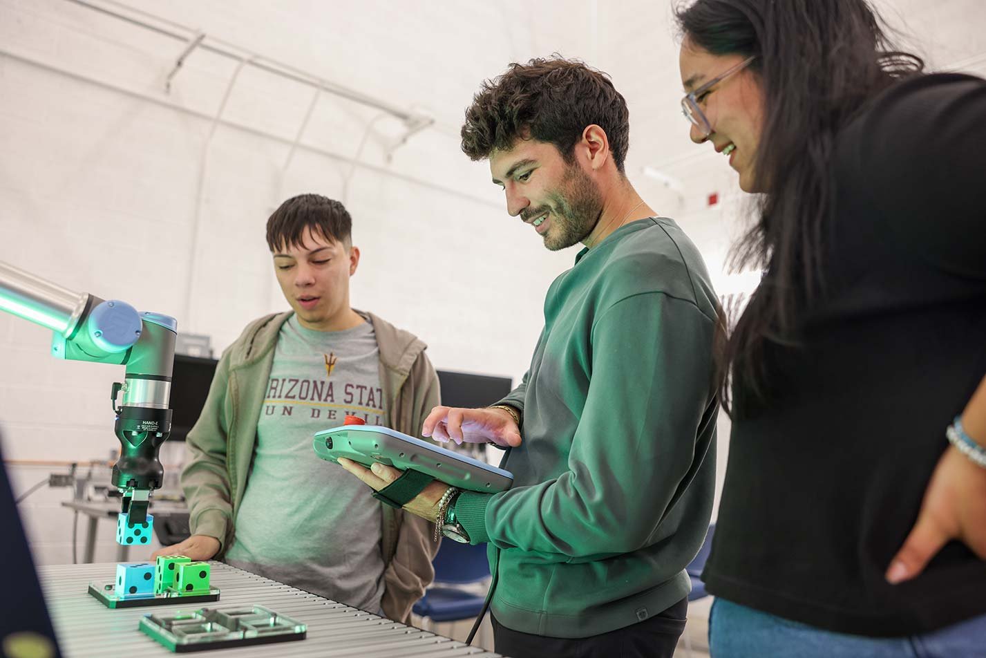 Students inspect robotic equipment, applying machine learning in ASU's Data Science, Analytics and Engineering (Bayesian Machine Learning), MS degree.