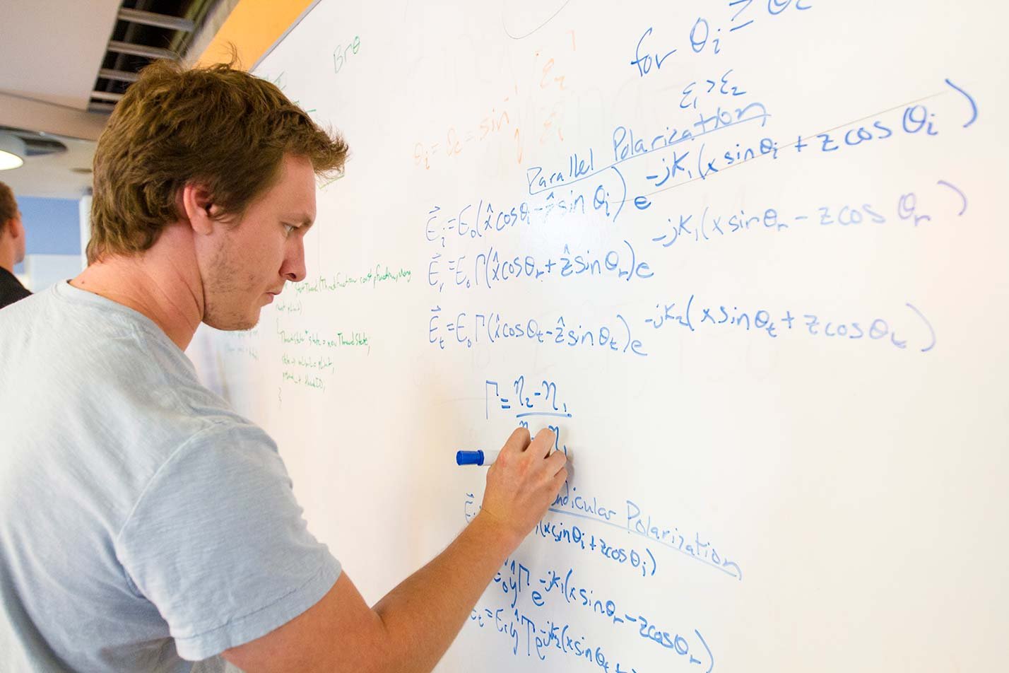 A student solves whiteboard equations in ASU's Data Science, Analytics and Engineering (Computational Mathematics and Data), MS degree.