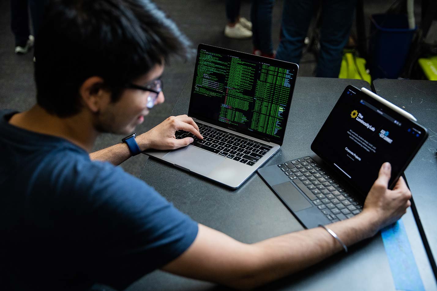 A student monitors code across devices, showcasing research in ASU's Data Science, Analytics and Engineering, PhD program.