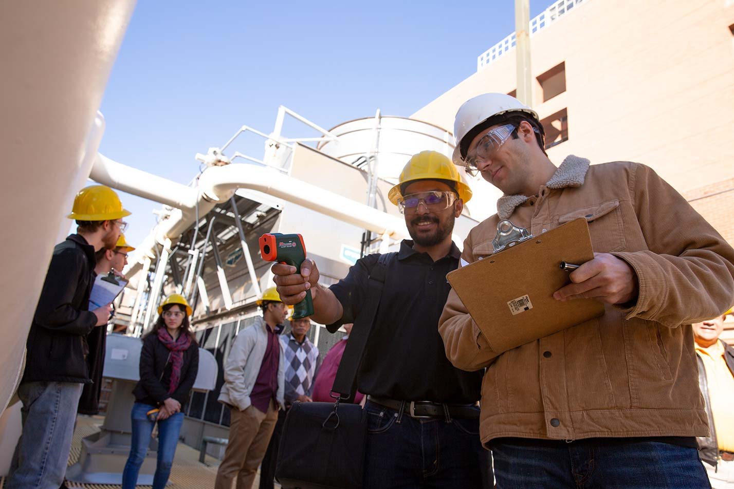 Engineers engage in equipment analysis on a site, highlighting practical skills in ASU's Engineering Management degree.
