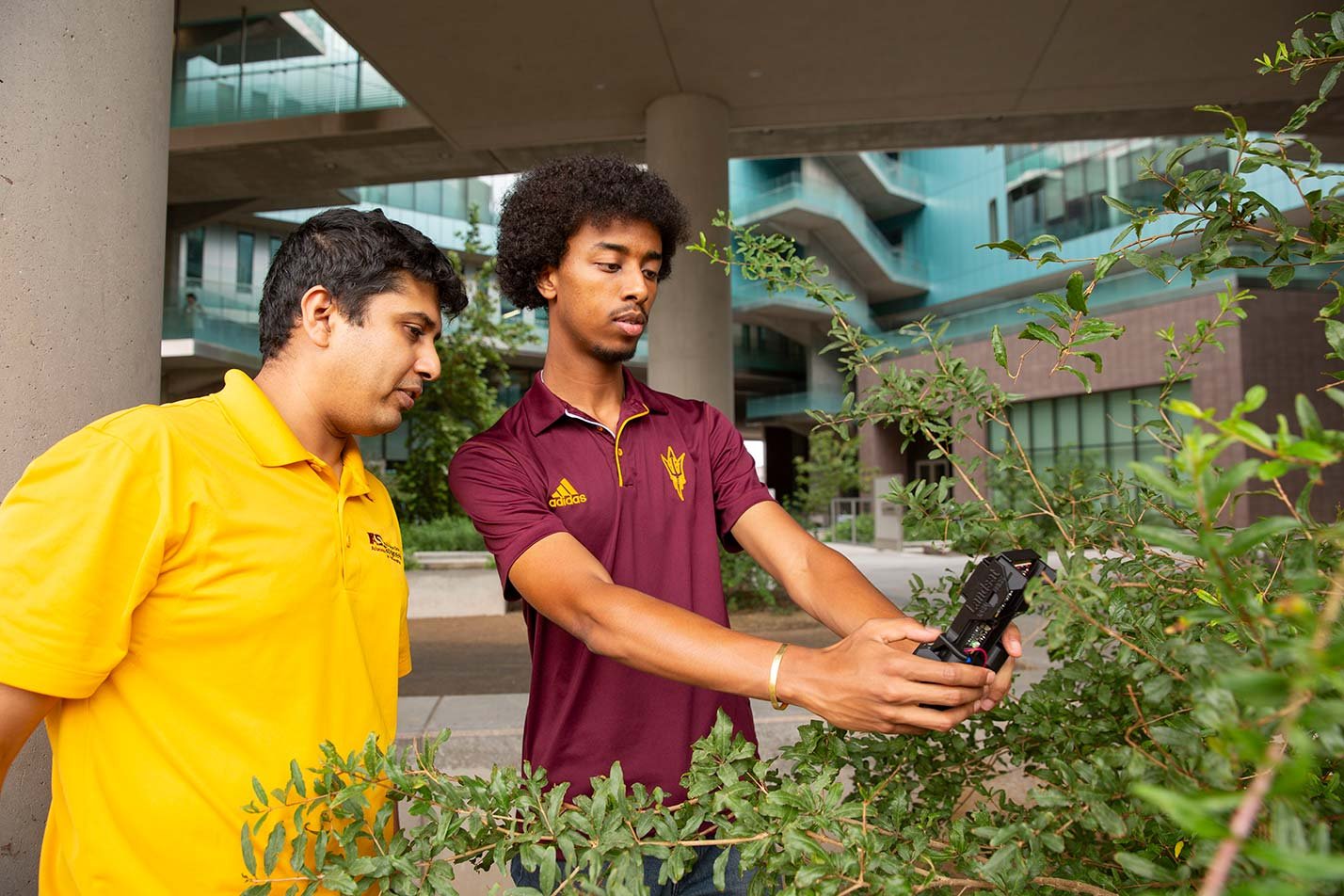 Two students observe and collect environmental data outdoors, embodying practical learning in ASU's Environmental Engineering degree.