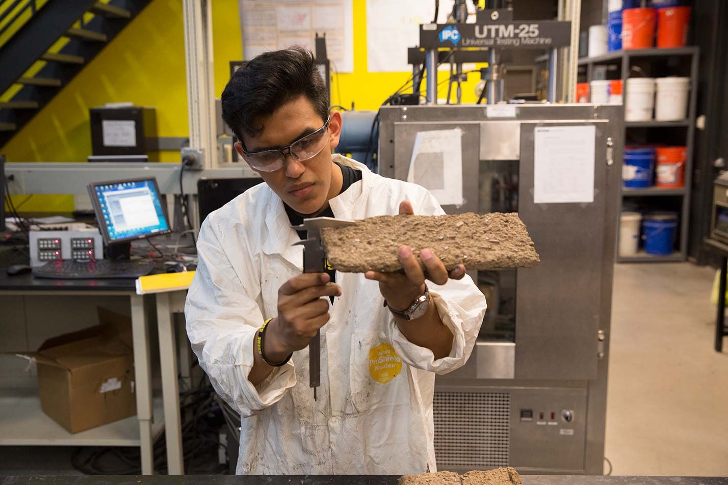 A researcher measures a concrete sample in a laboratory, highlighting applied testing in ASU's Environmental Engineering, MS program.