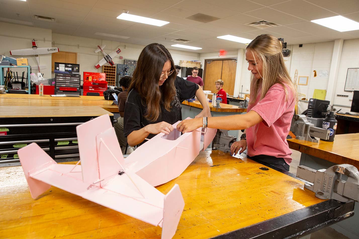 Students assemble a model aircraft in a workshop, highlighting design in ASU's Human Systems Engineering (Aviation Human Factors), MS program.